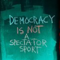 Eine Wand der in English steht seht: "Demokratie ist kein Zuschauersport"