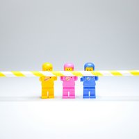 Drei Legofiguren halten einen Strohalm