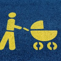 Eine Mutter mit Kinderwagen als Symbol auf einer Straße